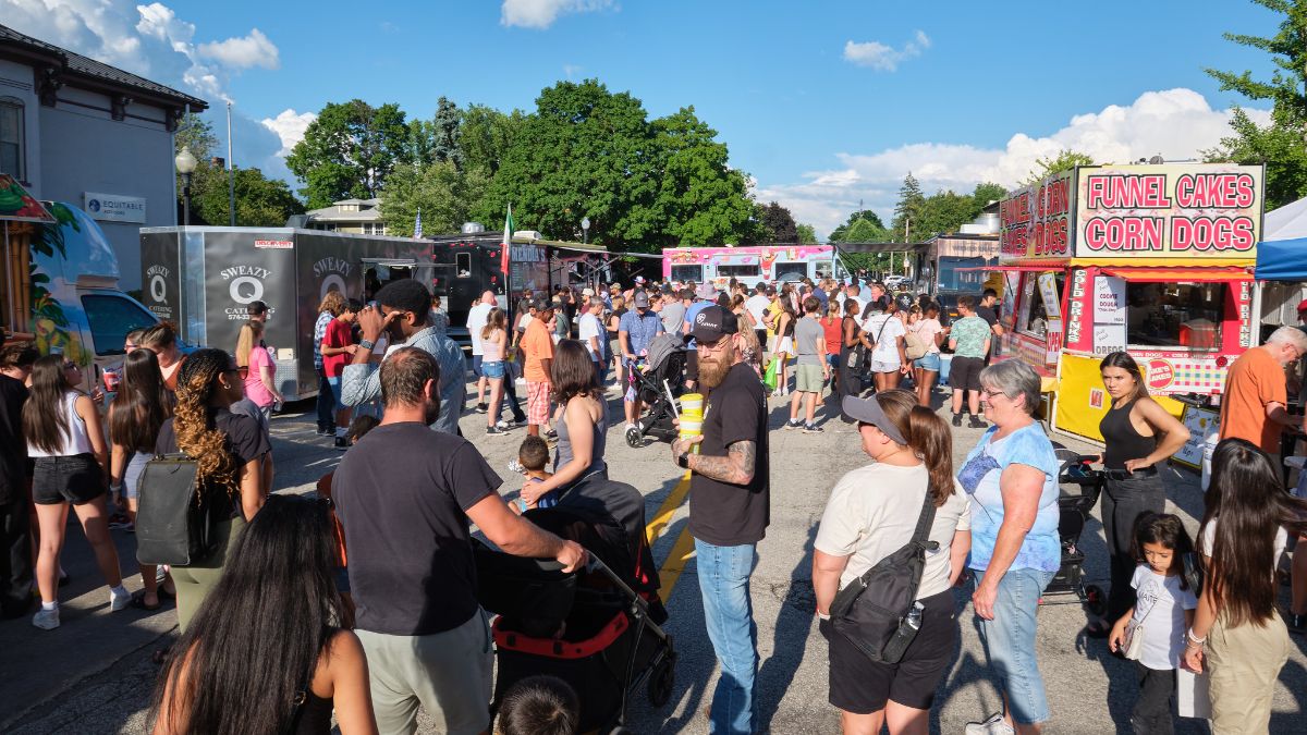 crowds gather downtown and enjoy food trucks in the street