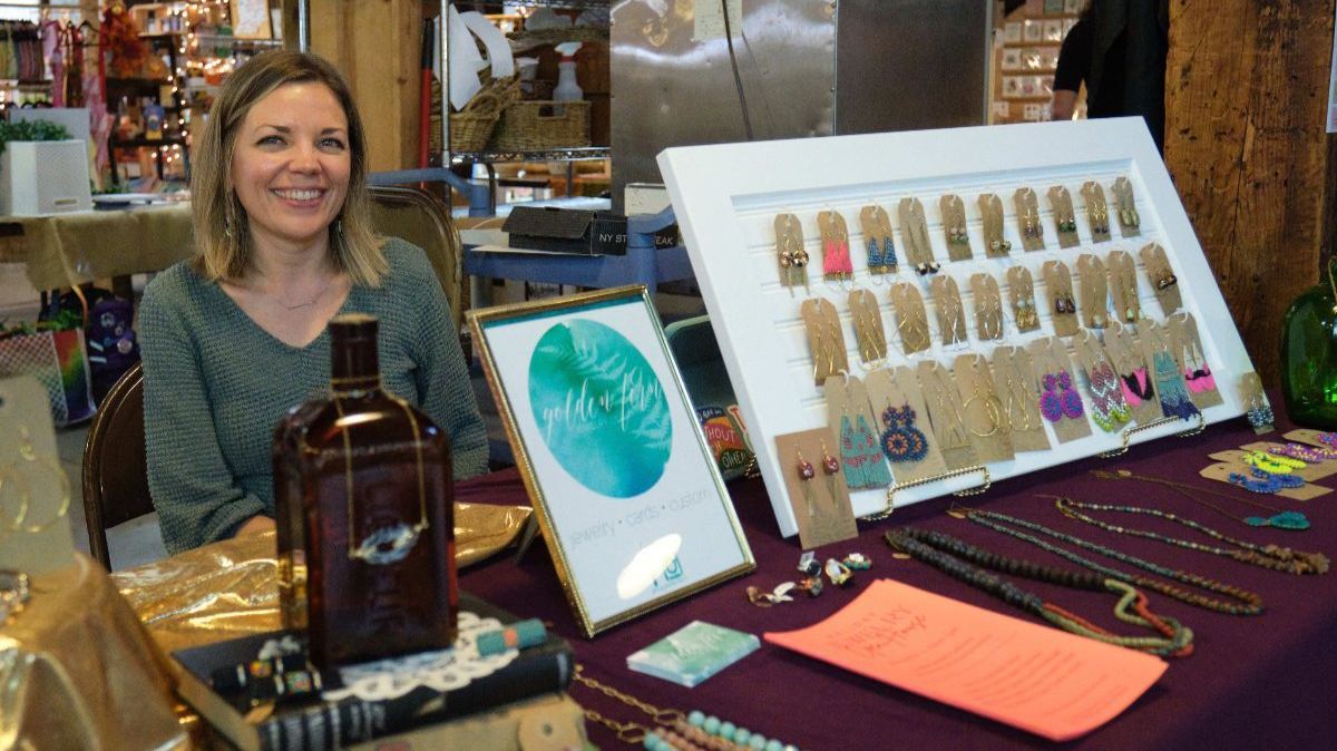 An artist with her work at a First Fridays event