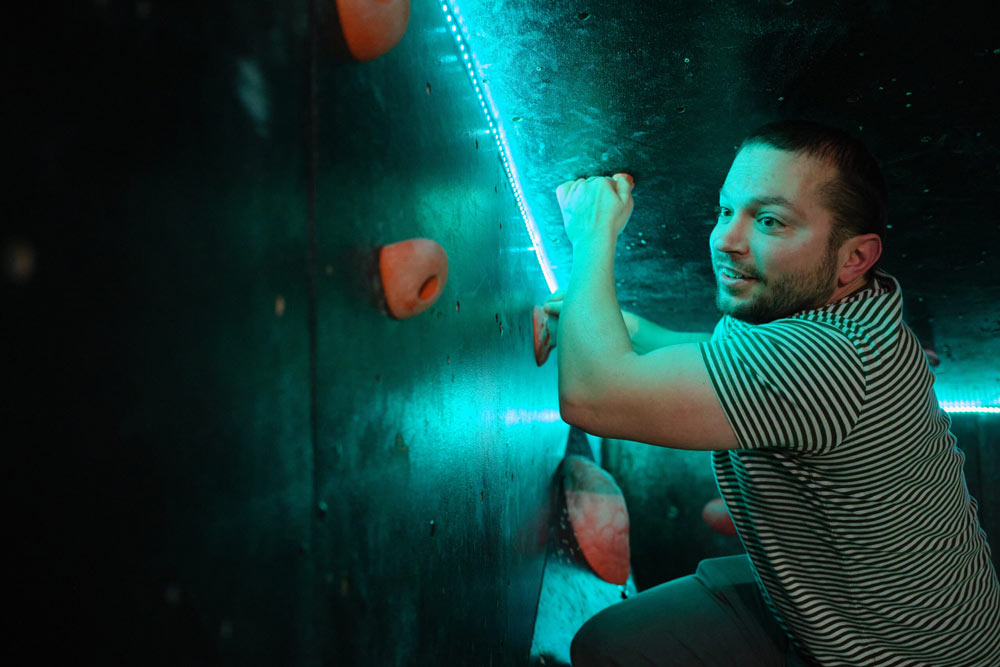 A person on a challenging climbing course at an indoor location